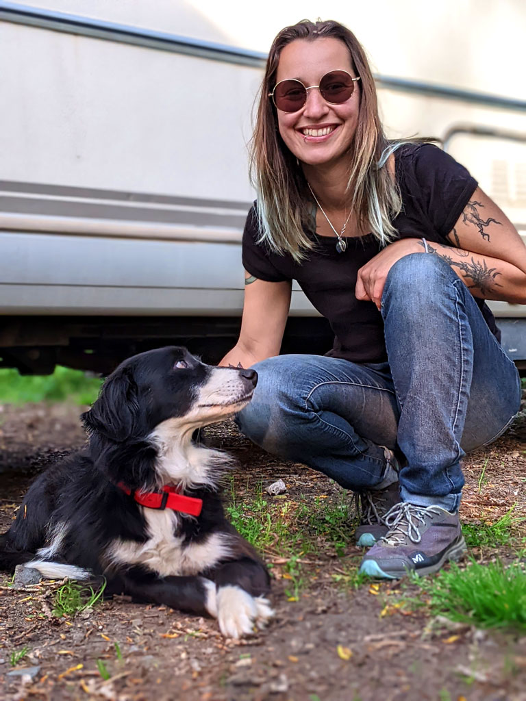 Portrait du dresseur canin souriant accroupis à côté d'un chien